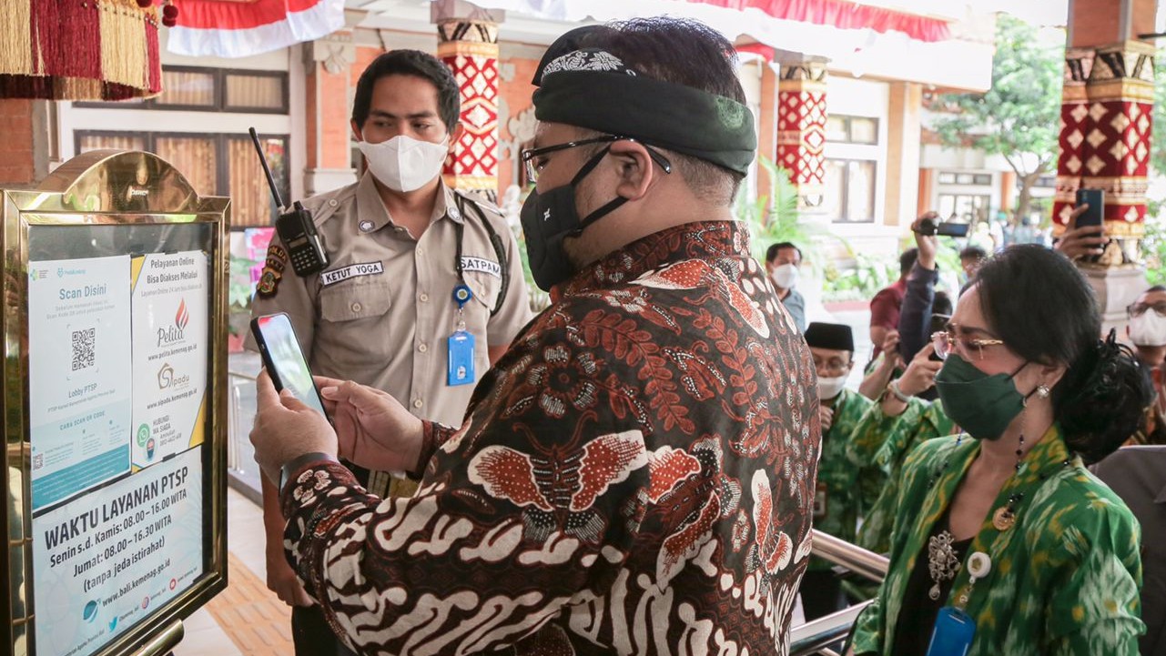 Menag scan barcode saat memasuki Rumah Pelayanan Agama dan Keagamaan Kanwil Kemenag Bali