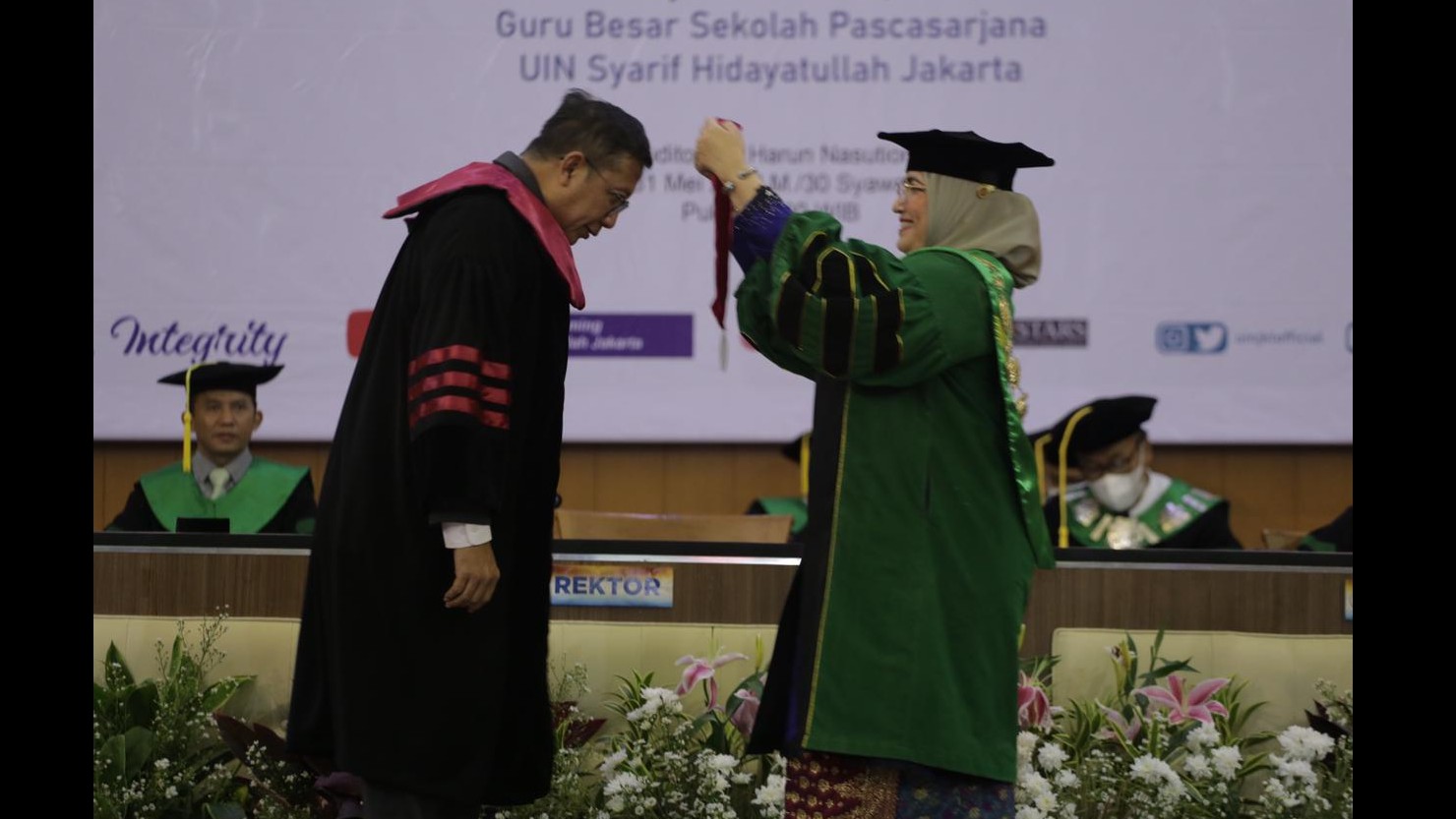 Rektor UIN Syahid Jakarta  Amani Lubis memasangkan toga kepada DR (Hc) Lukman Hakim Saifuddin