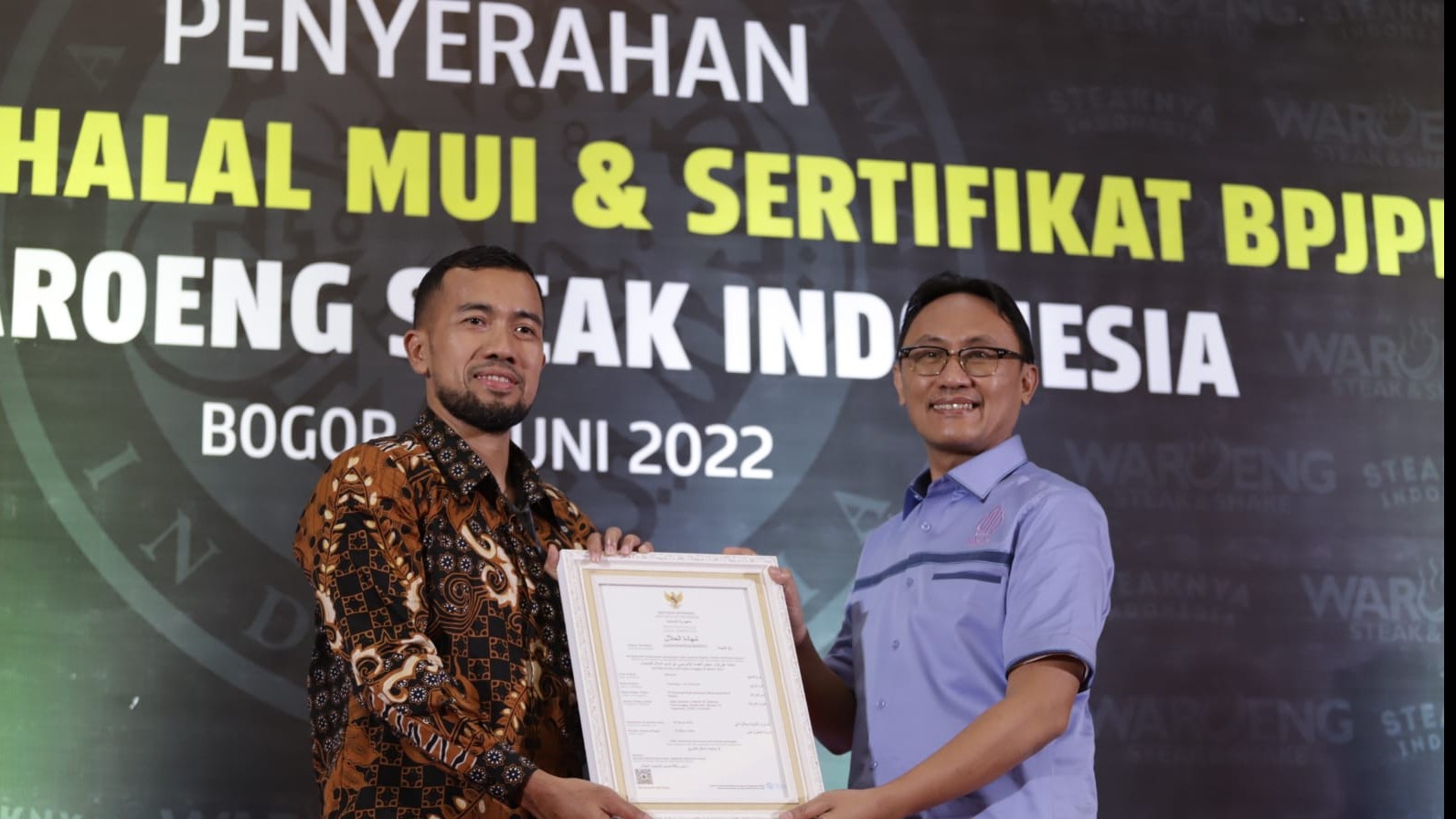 Kepala BPJPH Aqil Irham (berbaju biru) menyerahkan Sertifikat Halal kepada Pimpinan  PT Waroeng Steak Indonesia, Selasa (7/6/2022)