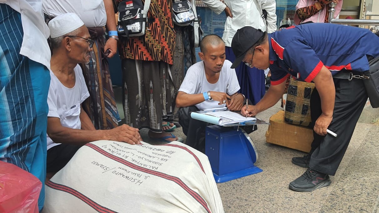 Petugas perusahaan kargo sedang menimbag barang jemaah yan akan dikirim ke Indonesia