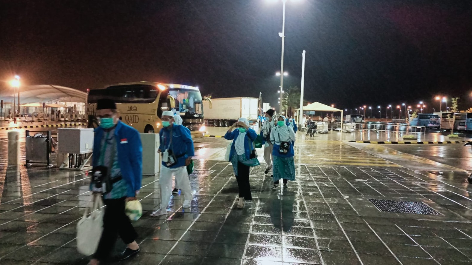 Rombongan Jemaah haji asal embarkasi Solo (SOC) saat awal turunya hujan di Bandara, Madinah.