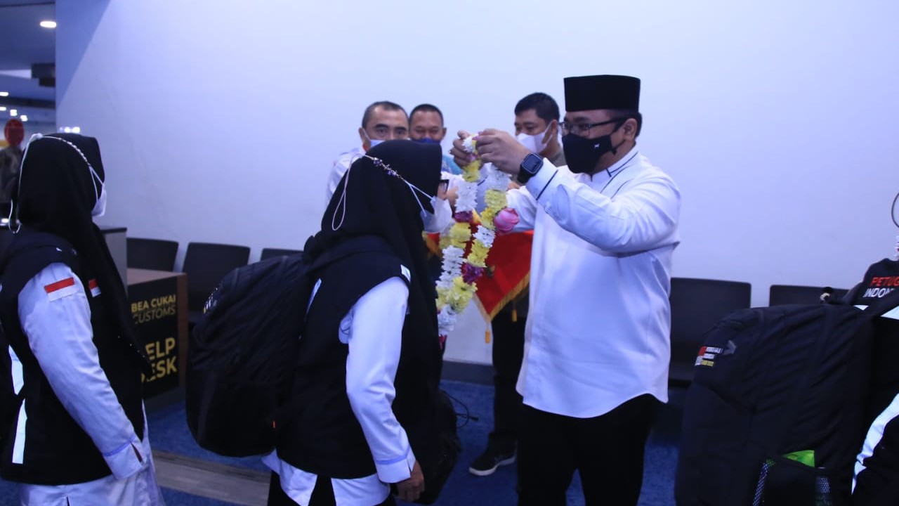 Menag Yaqut mengalungkan bunga kepada PPIH Dakaer Makkah setibanya di Bandara Sokaerno Hatta