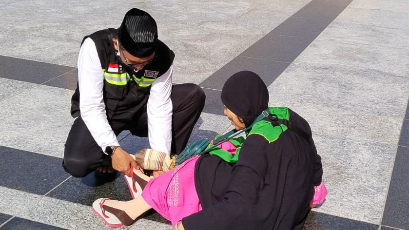 Petugas membantu jemaah di pelataran Masjid Nabawi